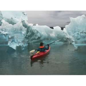  A Kayak Paddler Passes Sculpted Icebergs in Tracy Arm 